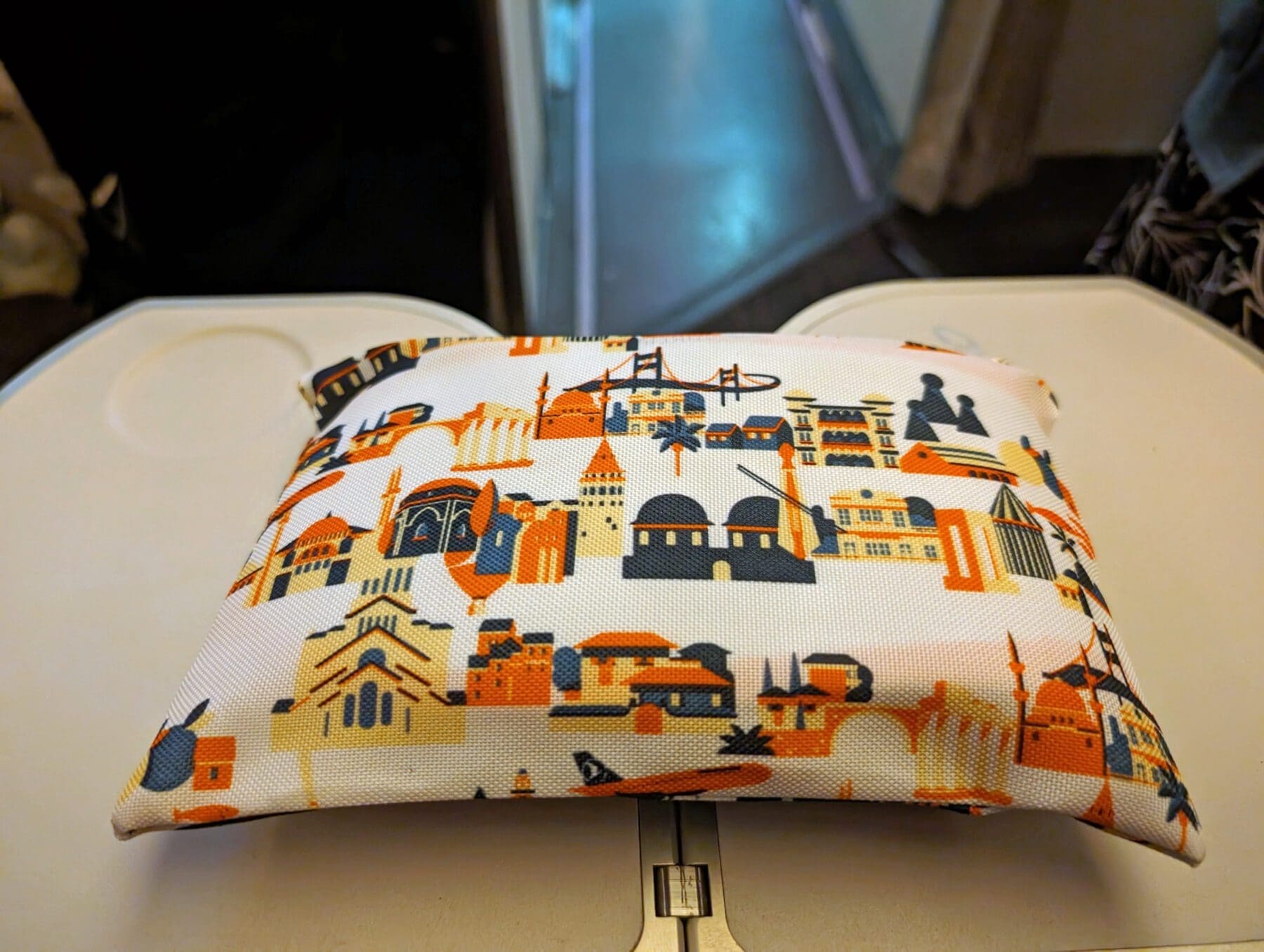 Turkish Airlines Food Review Economy Class 7 A pouch adorned with various architectural landmarks complements the Turkish Airlines meals as it rests elegantly on the airplane tray table.