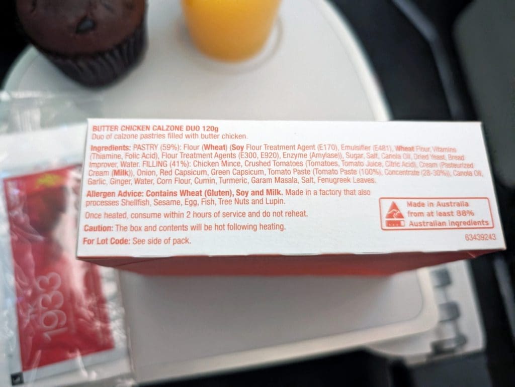 Turkish Airlines Food Review Economy Class 19 Box labeled "Butter Chicken Calzone Duos," reminiscent of Turkish Airlines meals, with ingredient list, allergy information, and manufacturing details. Contains wheat, gluten, and milk. Made in Australia from at least 88% Australian ingredients.
