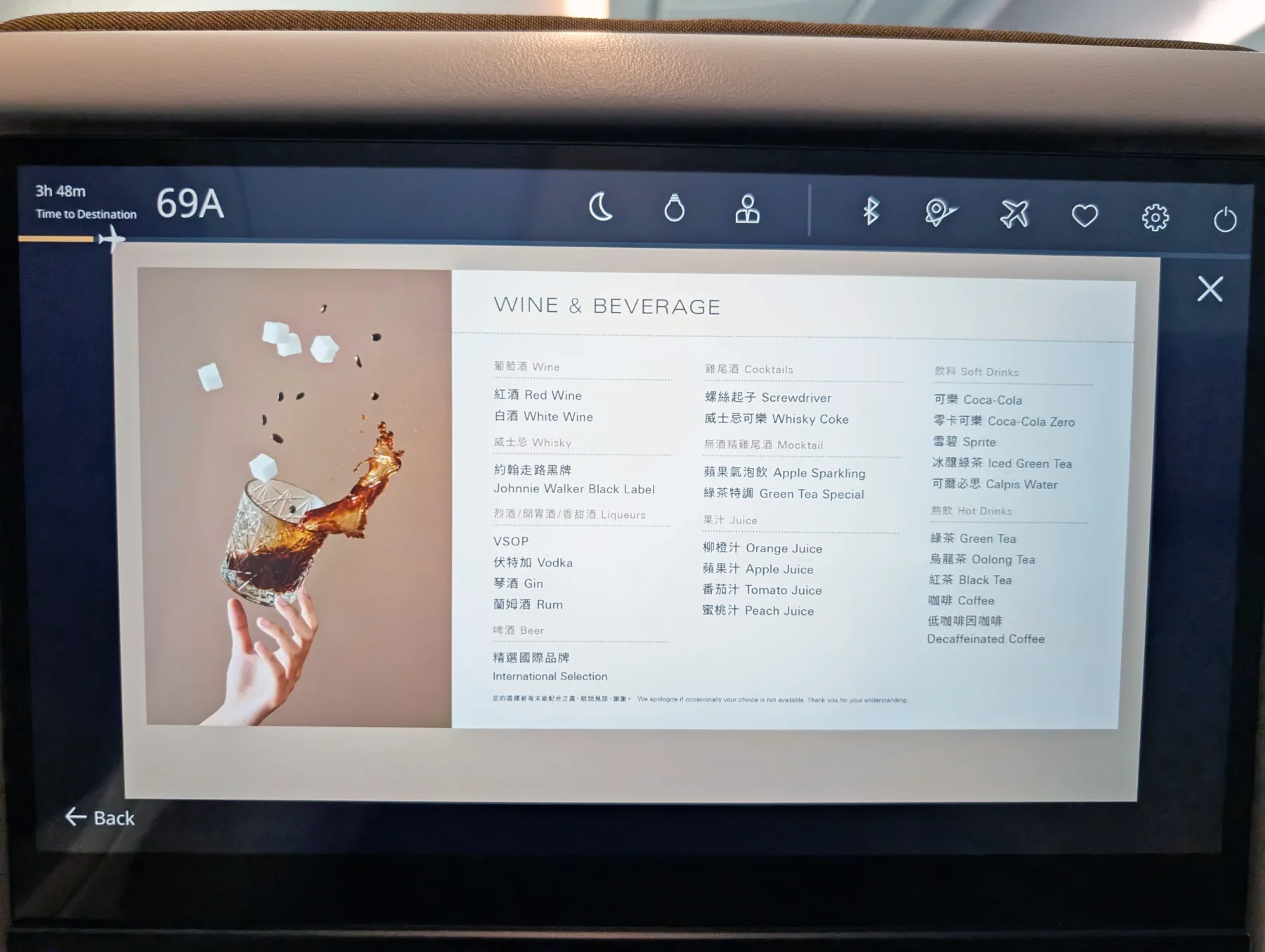 Starlux Airlines Review 2025: Taipei to Singapore 14 An in-flight entertainment screen displays a menu of wine, spirits, cocktails, soft drinks, juices, and hot beverages next to an image of a hand holding a glass with a splash and sugar cubes.